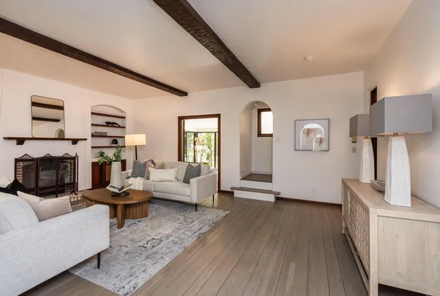 a living room with furniture and a wooden floor
