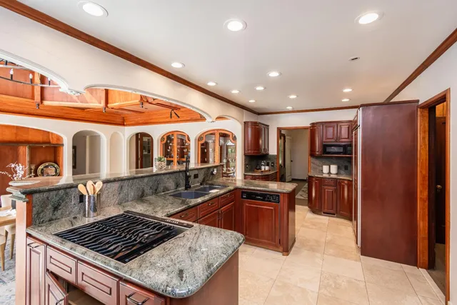 a kitchen with stainless steel appliances granite countertop a stove a sink and a refrigerator