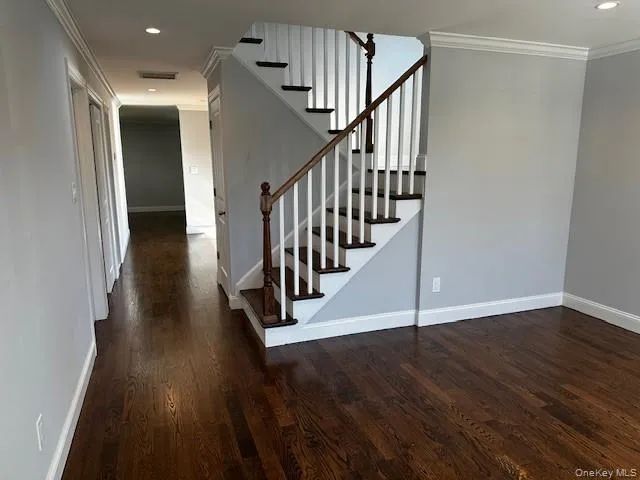 a view of a hallway with wooden floor and staircase