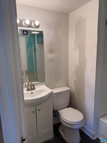 a bathroom with a toilet sink and mirror