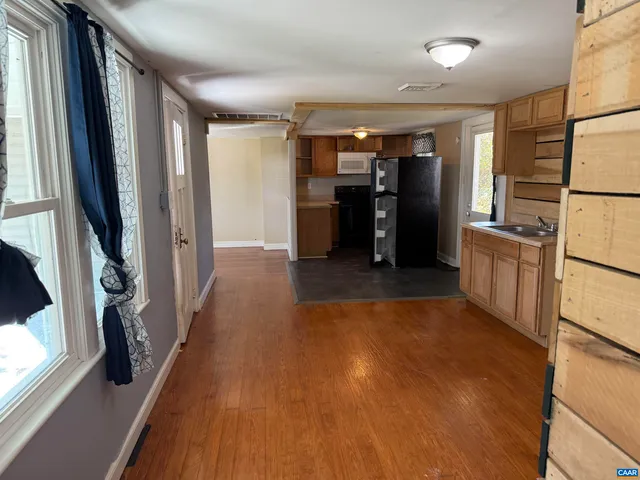 a view of a kitchen with furniture and a refrigerator