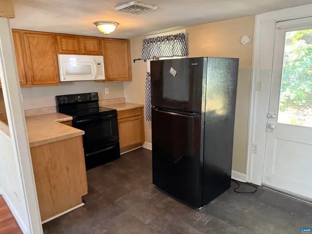 a kitchen with a refrigerator and a stove top oven