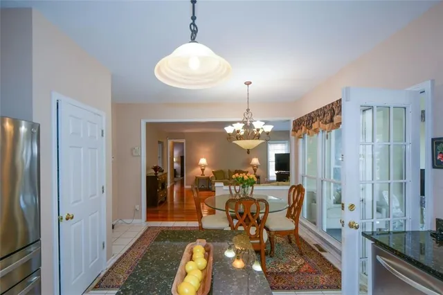 a view of a dining room with furniture a chandelier and wooden floor