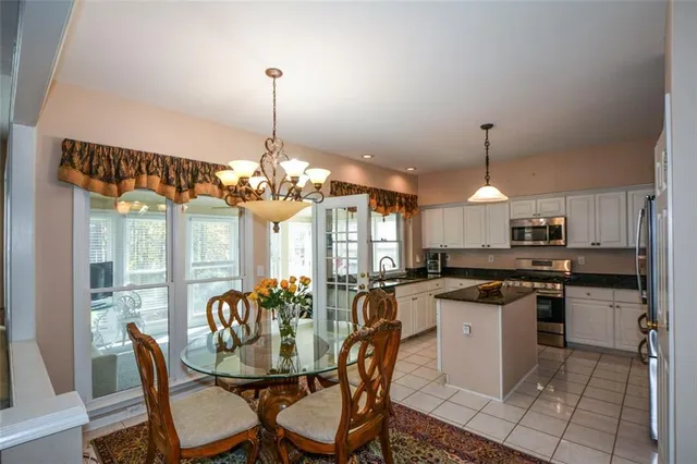 a living room with furniture a flat screen tv and a floor to ceiling window