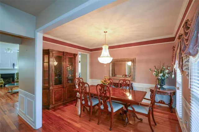 a dining room with furniture potted plants and wooden floor