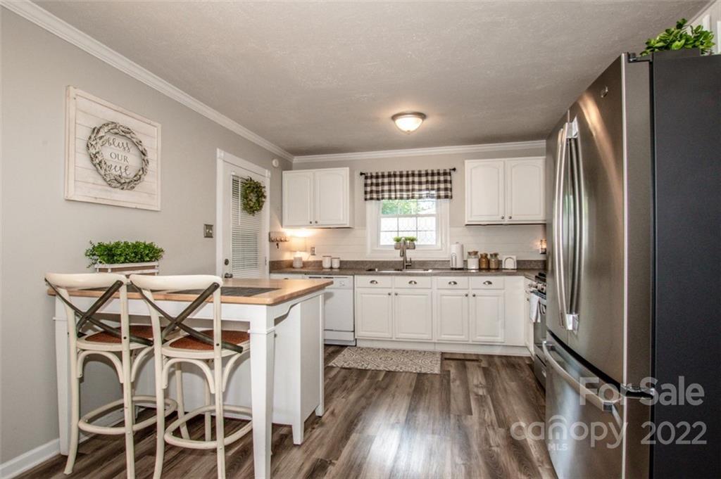406 Fieldstone Road Mooresville, NC 28115 - Photo 15 of 43 a kitchen with a refrigerator a sink and white cabinets