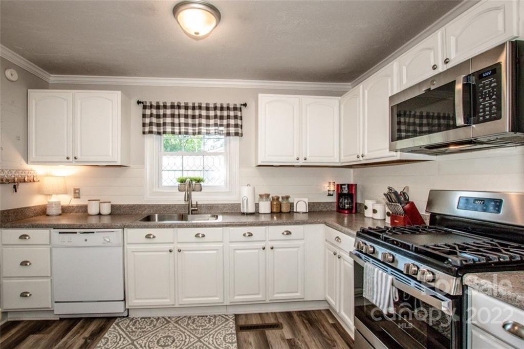 406 Fieldstone Road Mooresville, NC 28115 - Photo 19 of 43 a kitchen with granite countertop a stove a sink and dishwasher with white cabinets