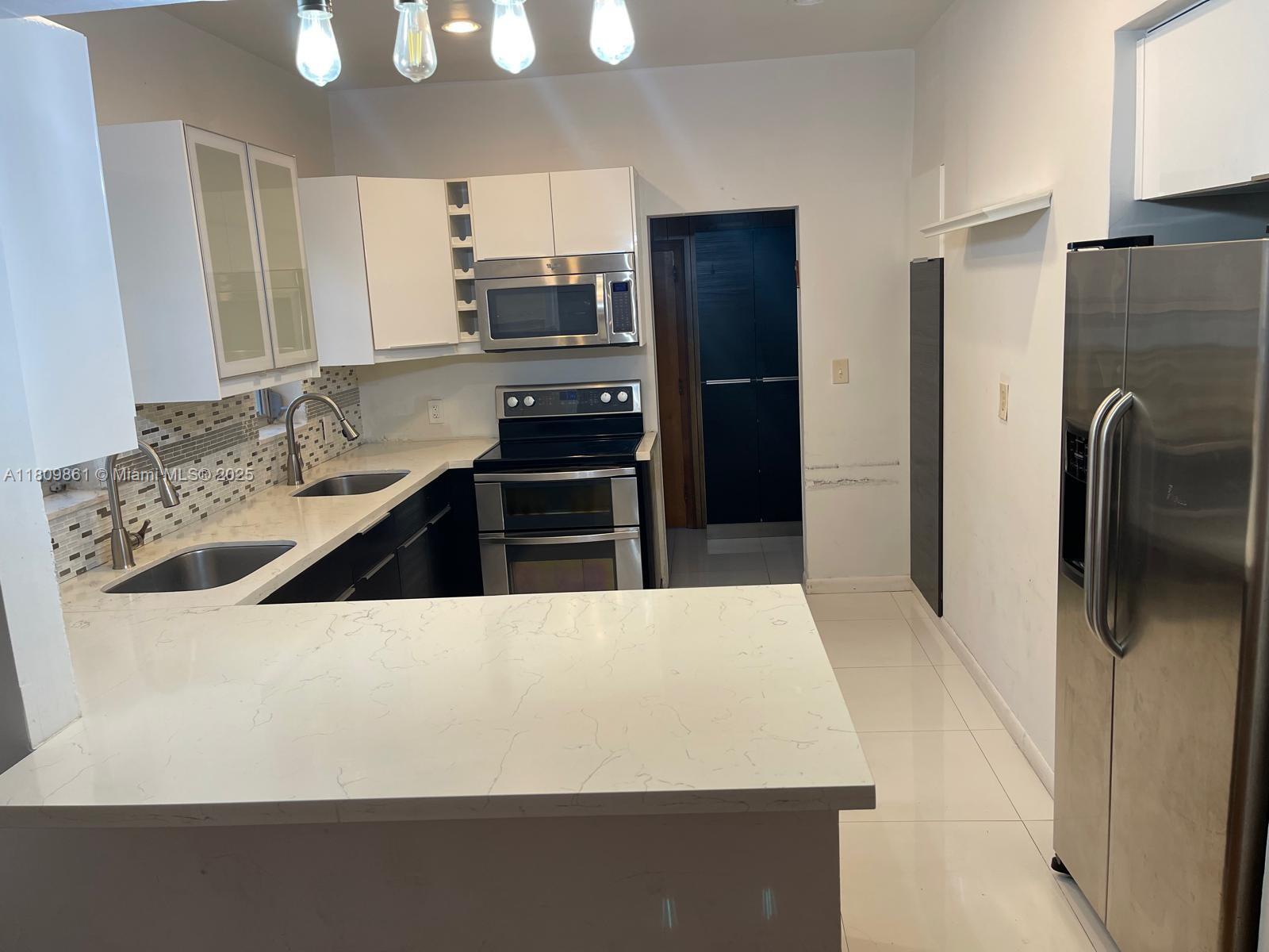 a kitchen with stainless steel appliances a refrigerator sink and stove