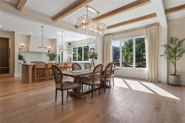 a kitchen with stainless steel appliances kitchen island granite countertop a table chairs sink and cabinets