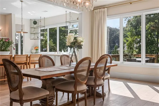 a dining room filled chandelier and wooden floor