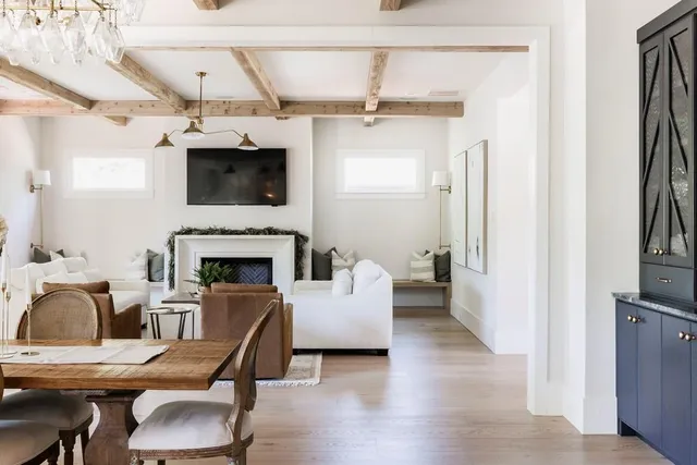 a open kitchen with stainless steel appliances granite countertop a large stove a sink dishwasher and a fireplace with wooden floor