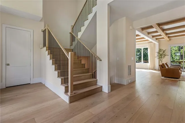 a view of a livingroom with wooden floor and stairs