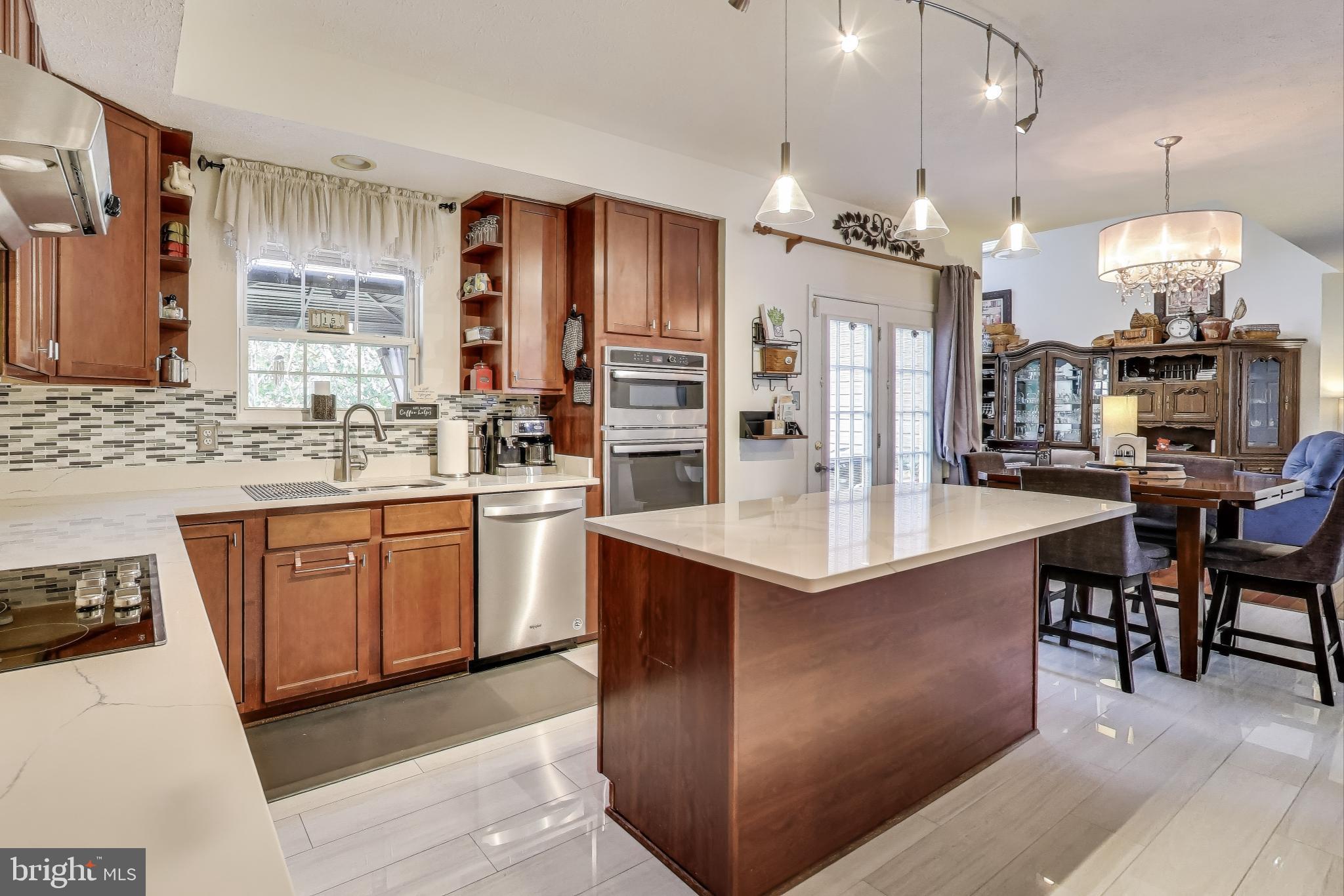 2323 Springdale Lane Waldorf, MD 20603 - Photo 11 of 51 a kitchen with stainless steel appliances granite countertop a sink a stove a refrigerator a dining table and chairs