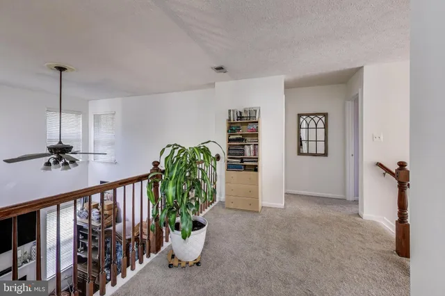 a view of a hallway with wooden floor and stairs