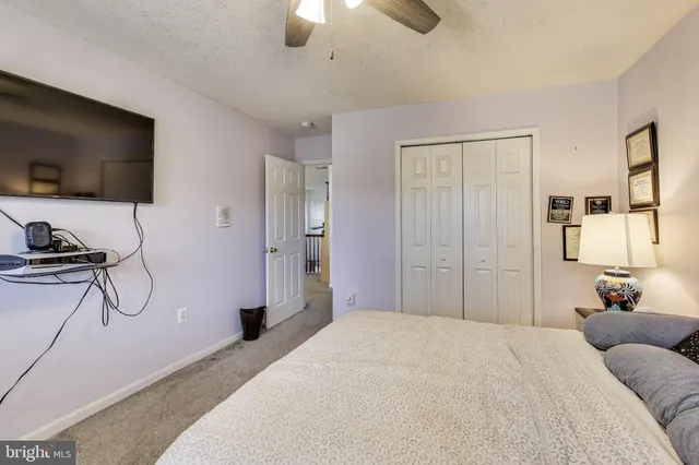 a bedroom with a bed and a flat tv screen on the dresser