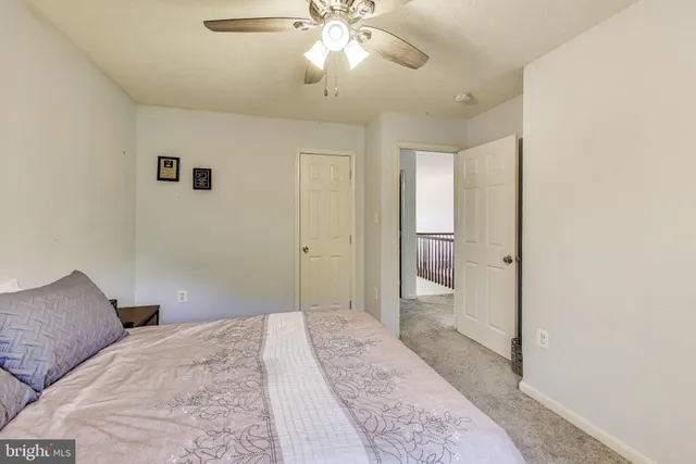 a bedroom with a large bed and a chandelier fan
