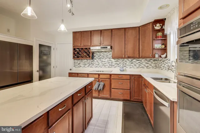 a kitchen with stainless steel appliances kitchen island granite countertop a sink stove and refrigerator