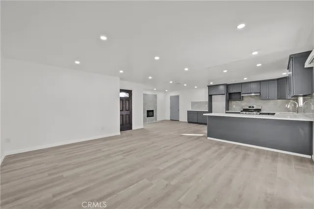 a kitchen with stainless steel appliances granite countertop a stove a sink and a refrigerator