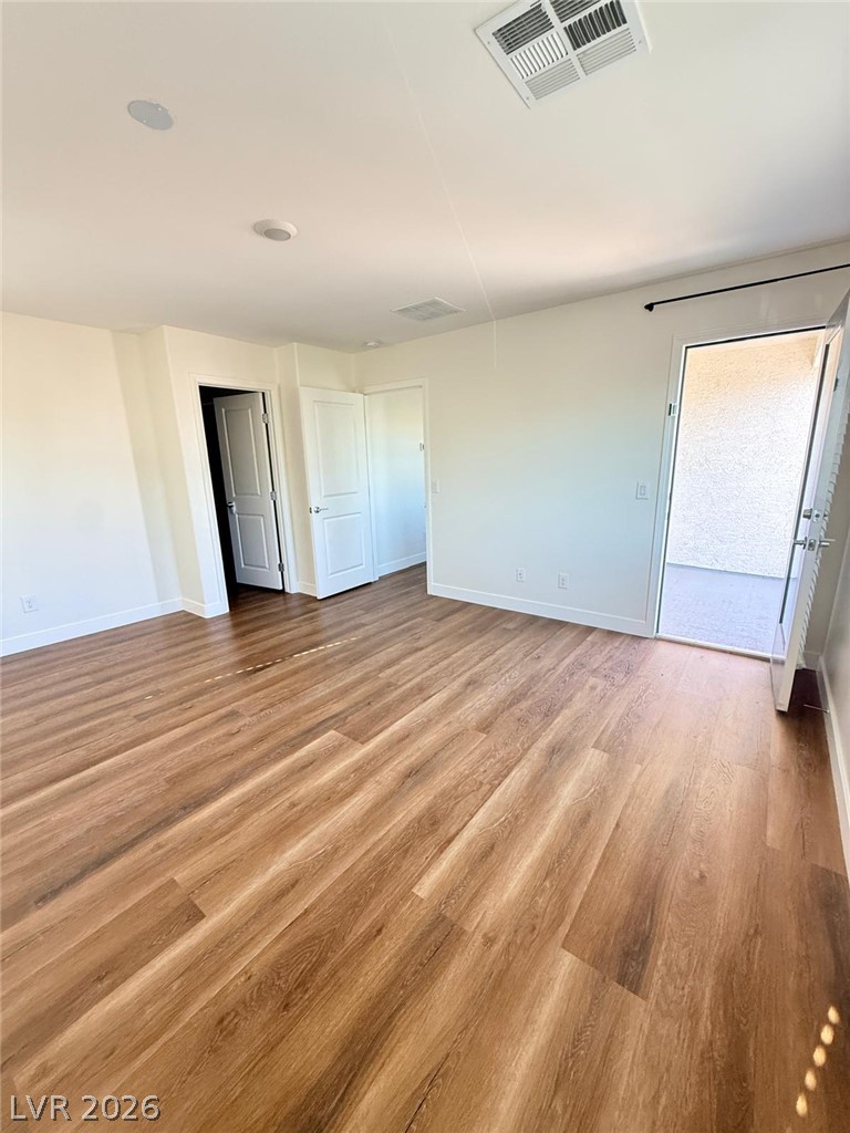 12232 Azure Gate Road, Unit 1 Las Vegas, NV 89183 - Photo 9 of 20 Rich wood-plank flooring runs throughout this versatile interior space opening directly to a private patio.