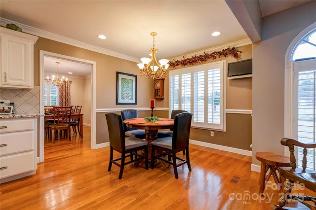 a view of a a dining room with furniture window and wooden floor