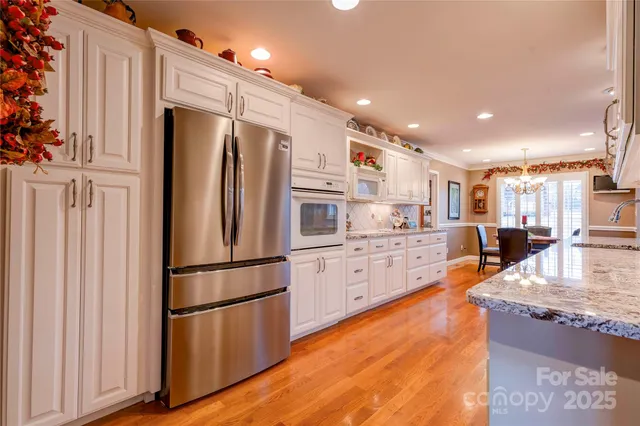 a kitchen with stainless steel appliances granite countertop a refrigerator a stove and a sink