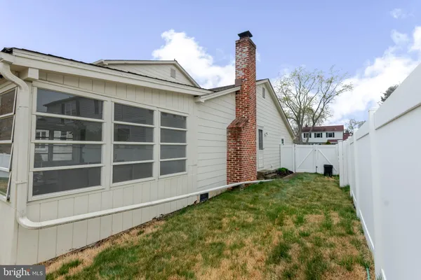 a view of a house with a large window and wooden fence