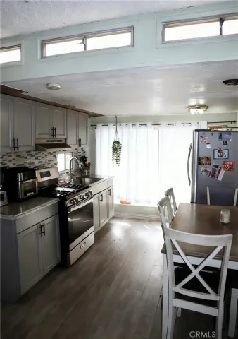 a kitchen with stainless steel appliances kitchen island granite countertop a stove a sink and a refrigerator