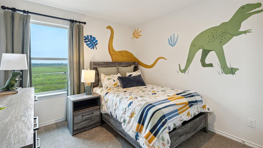 140 Pheasant Run Road Terrell, TX 75160 - Photo 24 of 26 Bedroom featuring a large window, neutral carpeting, and a built-in wall outlet