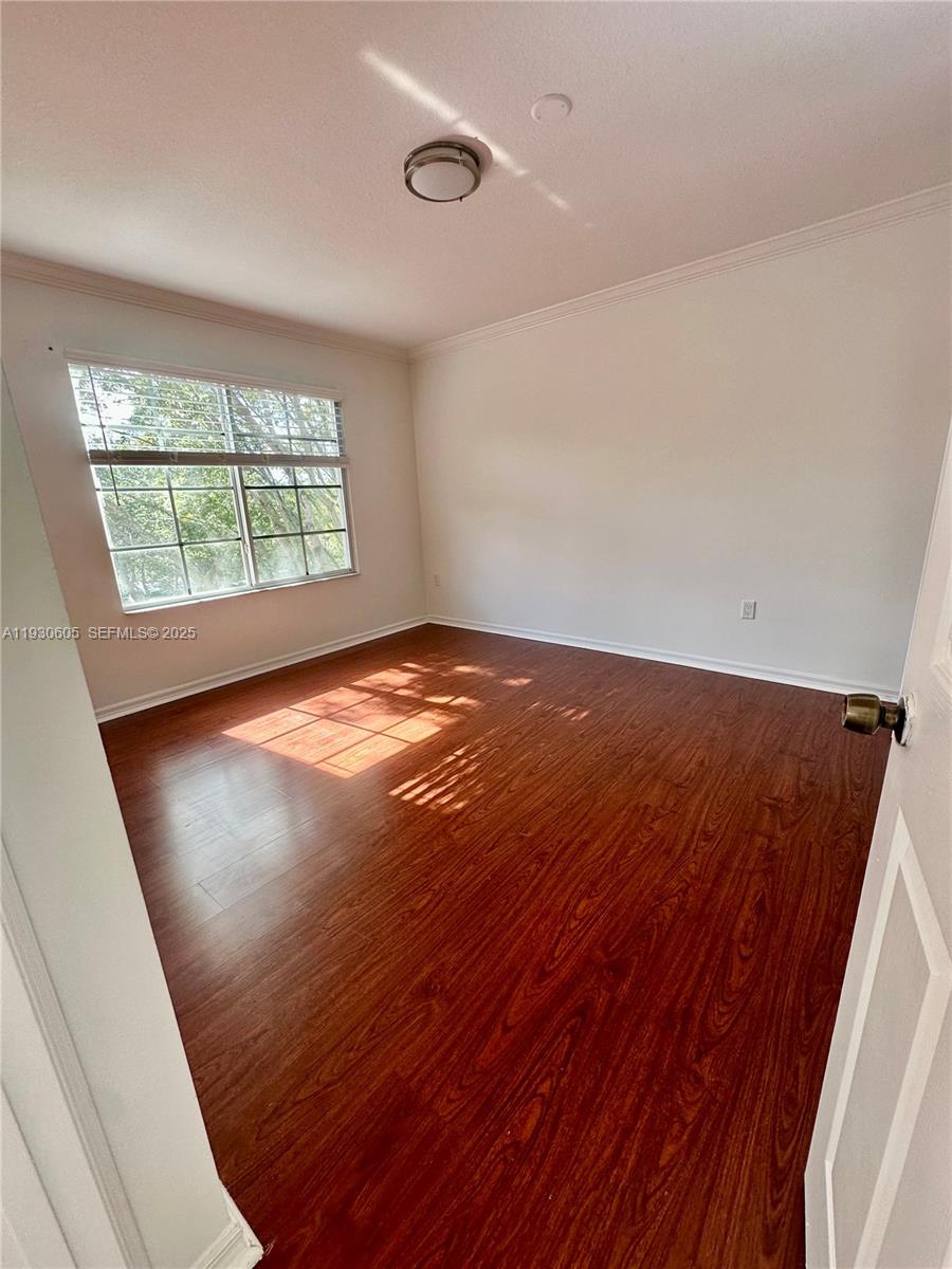 4190 San Marino Boulevard, Unit 303 West Palm Beach, FL 33409 - Photo 13 of 19 an empty room with wooden floor and windows