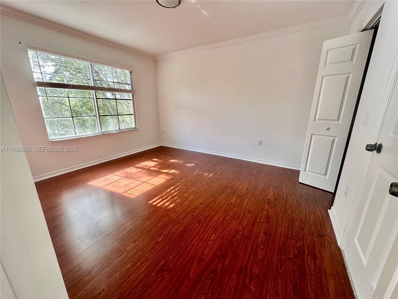 4190 San Marino Boulevard, Unit 303 West Palm Beach, FL 33409 - Photo 14 of 19 an empty room with wooden floor and windows
