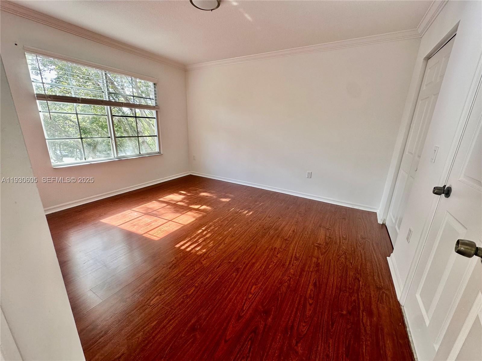 4190 San Marino Boulevard, Unit 303 West Palm Beach, FL 33409 - Photo 15 of 19 an empty room with wooden floor and windows