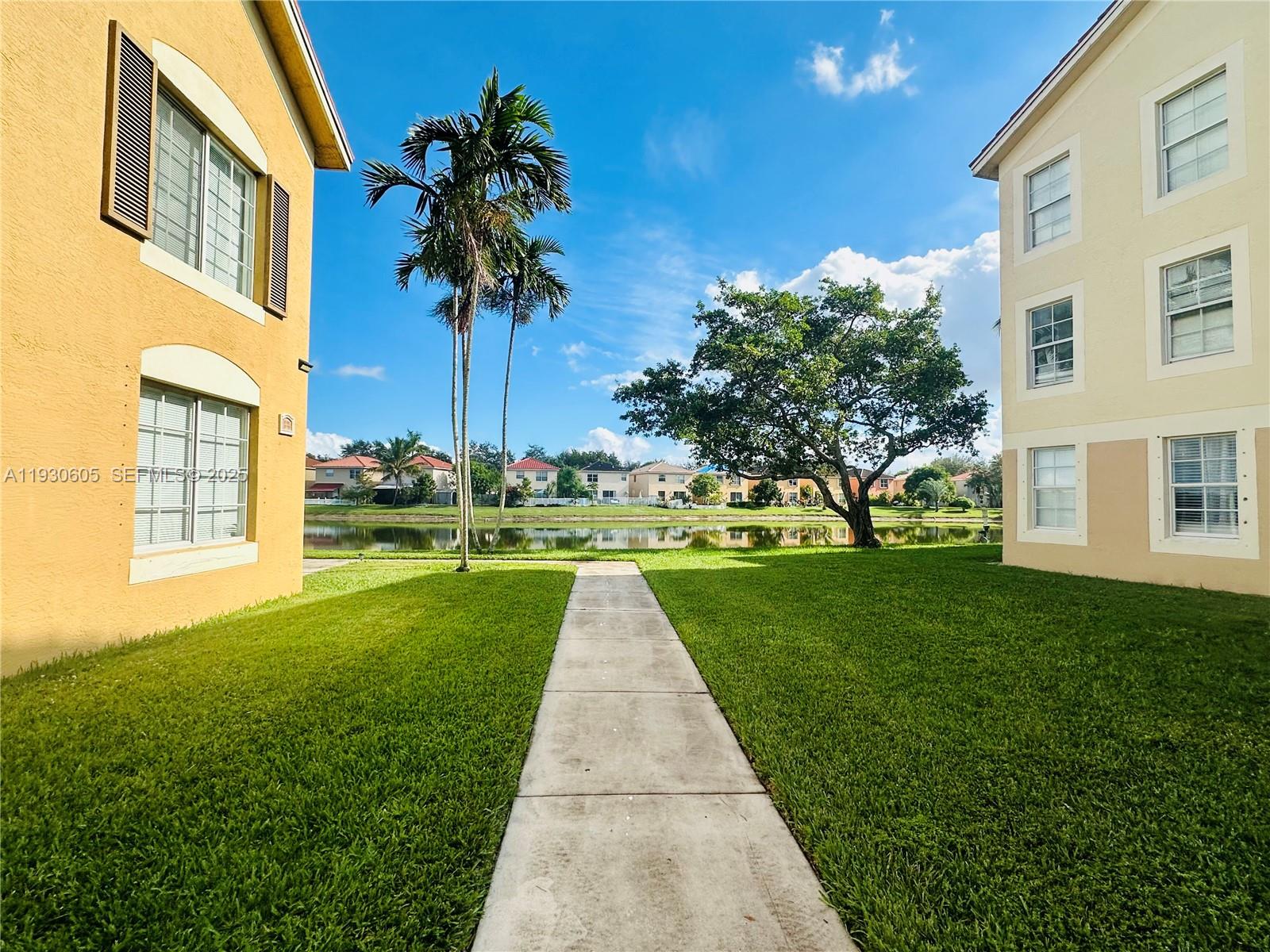 4190 San Marino Boulevard, Unit 303 West Palm Beach, FL 33409 - Photo 2 of 19 a front view of a house with a yard