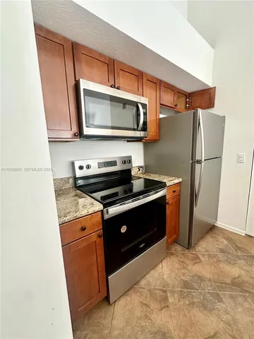 a kitchen with stainless steel appliances a stove a microwave and a refrigerator