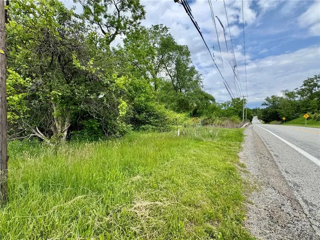 a view of a road with a house in the background