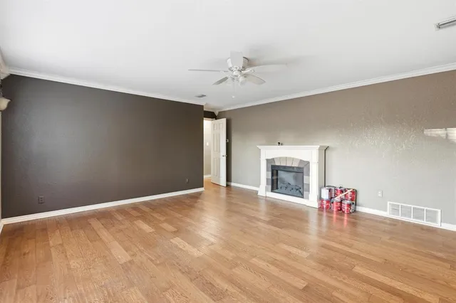 a view of an empty room with a window and a fireplace
