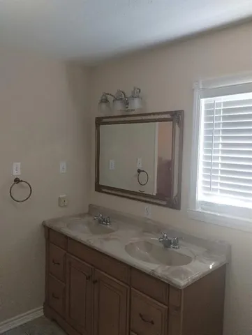 a bathroom with a granite countertop sink a mirror and with toilet