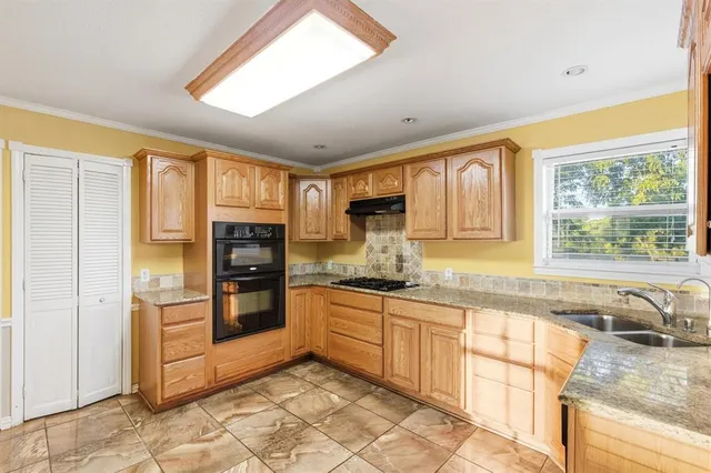 a kitchen with stainless steel appliances granite countertop a refrigerator and wooden cabinets