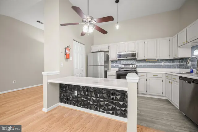 a open kitchen with cabinets a sink and stainless steel appliances