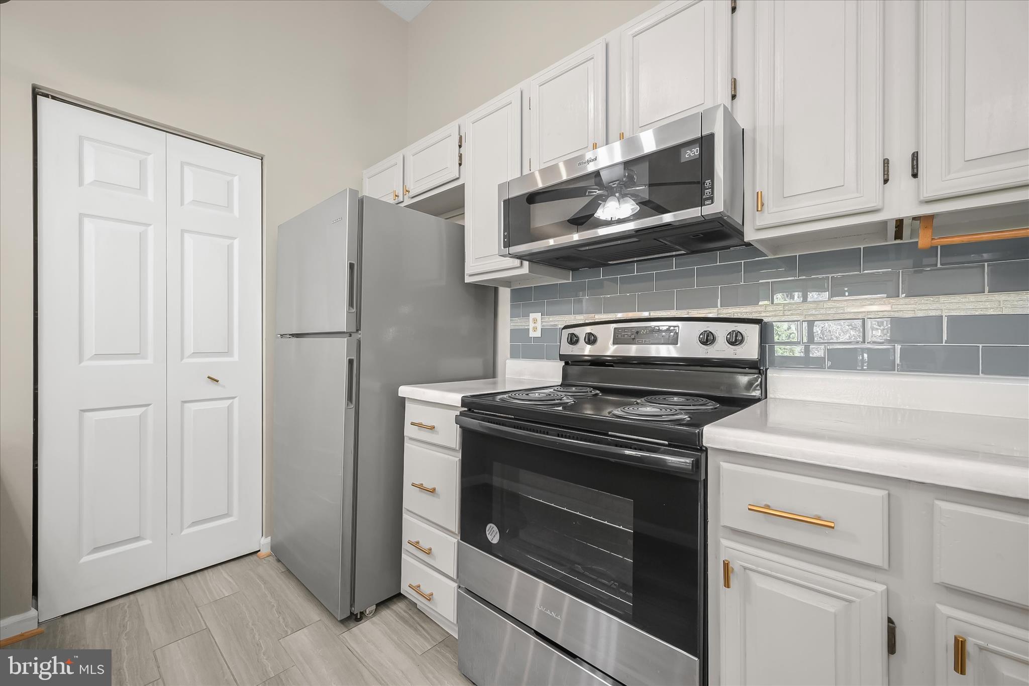 12309 Silvergate Way, Unit 908K Germantown, MD 20874 - Photo 12 of 37 a kitchen with stainless steel appliances granite countertop white cabinets and a stove top oven