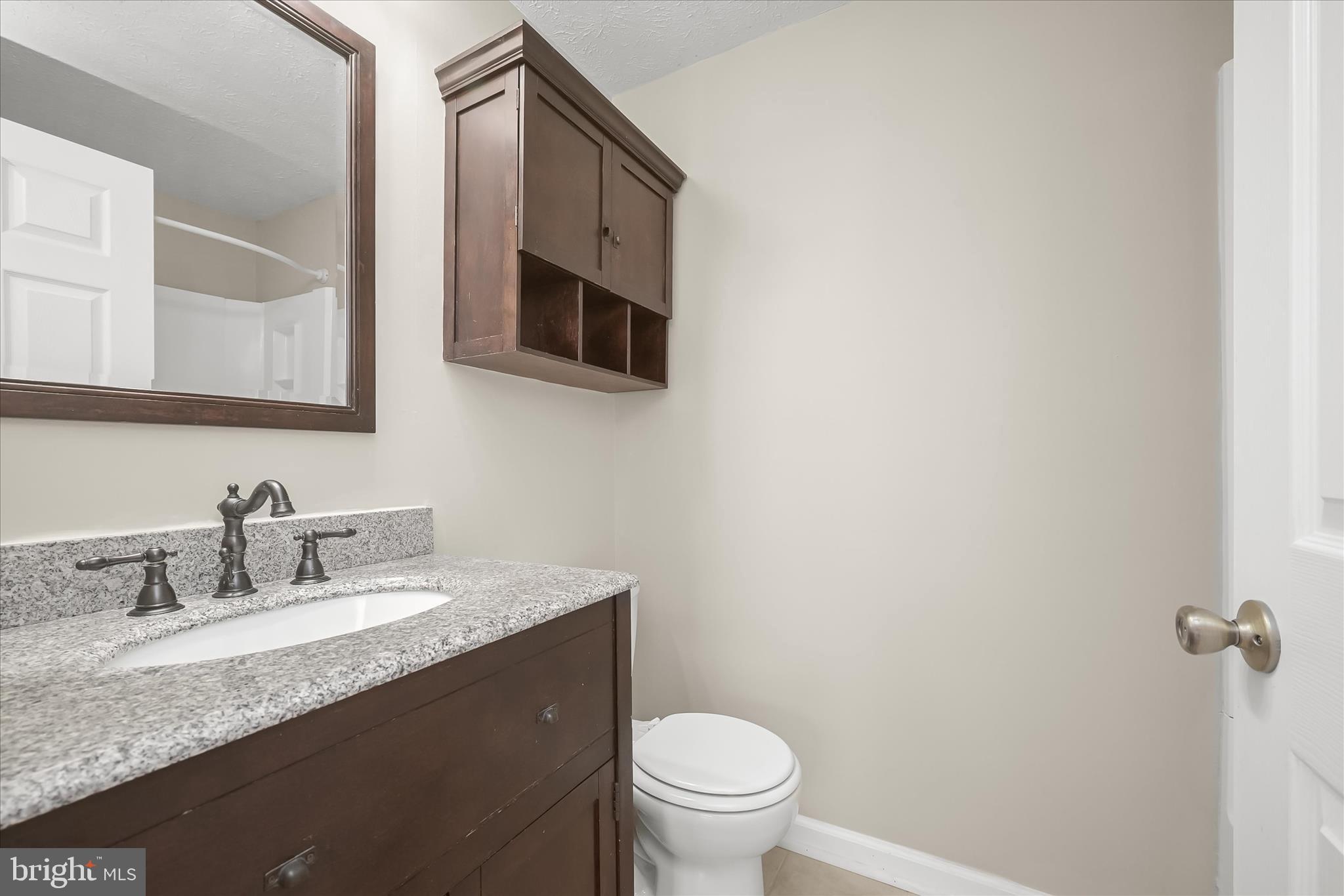 12309 Silvergate Way, Unit 908K Germantown, MD 20874 - Photo 20 of 37 a bathroom with a granite countertop sink mirror vanity and toilet