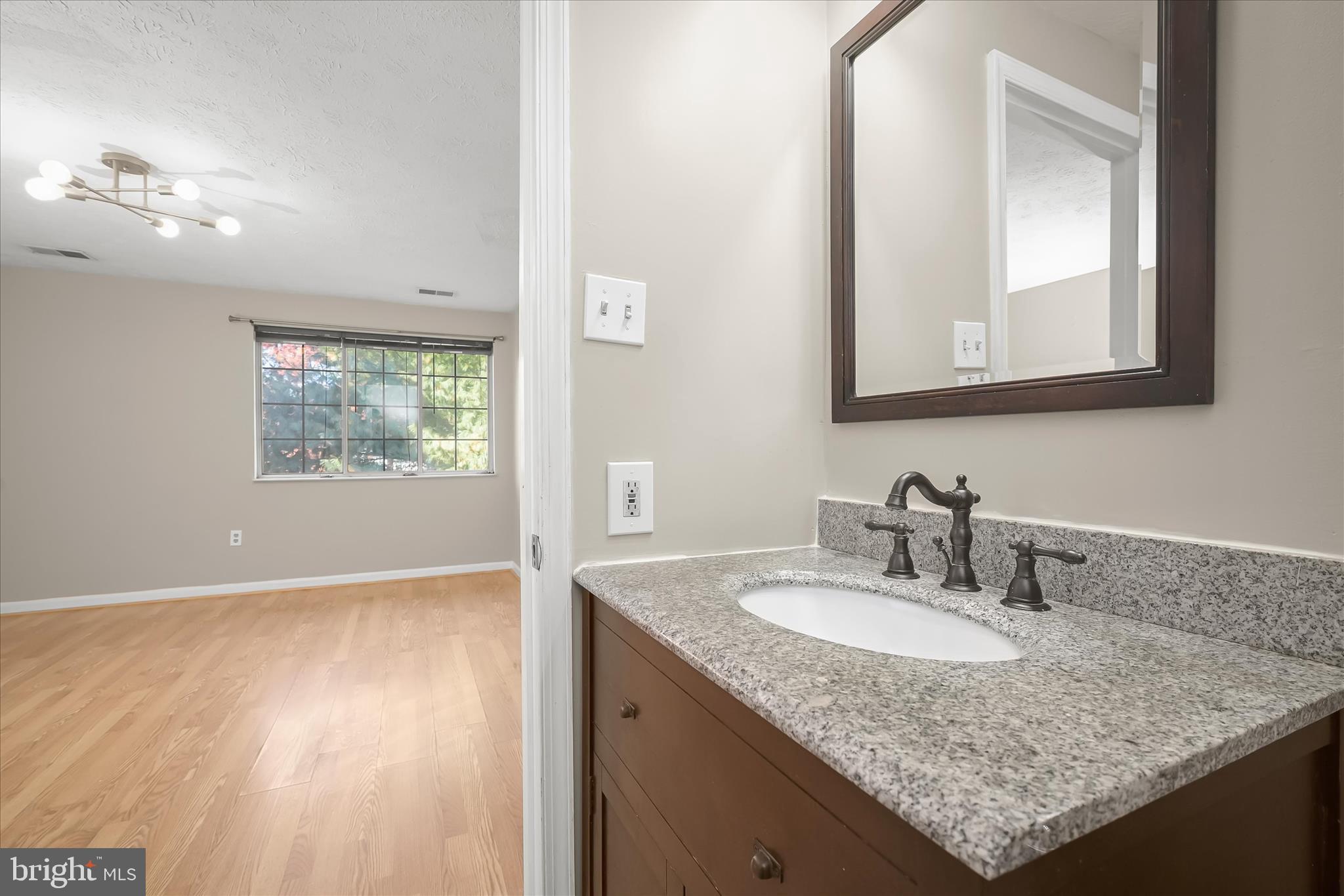 12309 Silvergate Way, Unit 908K Germantown, MD 20874 - Photo 21 of 37 a bathroom with a granite countertop sink a large mirror and a window