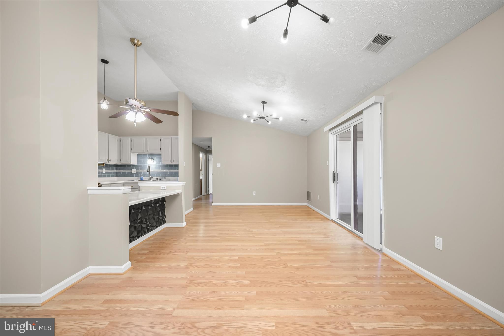 12309 Silvergate Way, Unit 908K Germantown, MD 20874 - Photo 6 of 37 a large white kitchen with kitchen island a stove a sink a refrigerator and chandelier