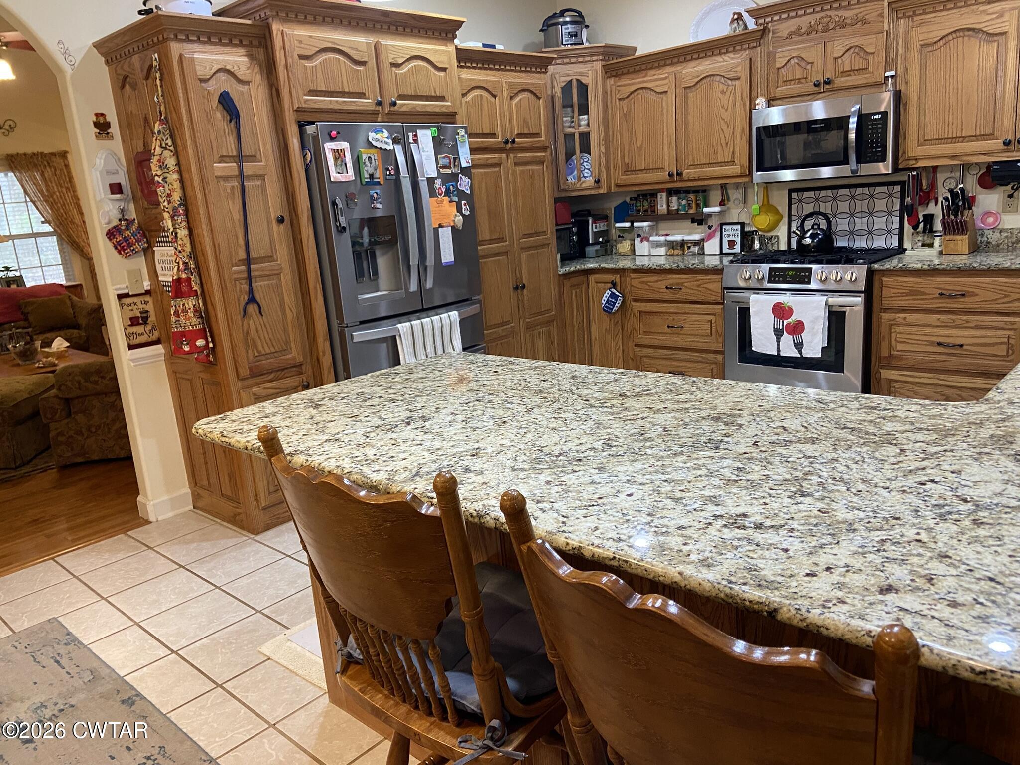 495 Knuckles Road Henderson, TN 38340 - Photo 13 of 80 a kitchen with stainless steel appliances granite countertop a sink stove and refrigerator