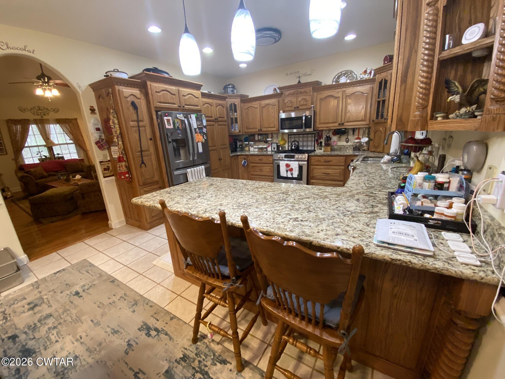 495 Knuckles Road Henderson, TN 38340 - Photo 14 of 80 a kitchen with stainless steel appliances kitchen island granite countertop a sink and cabinets