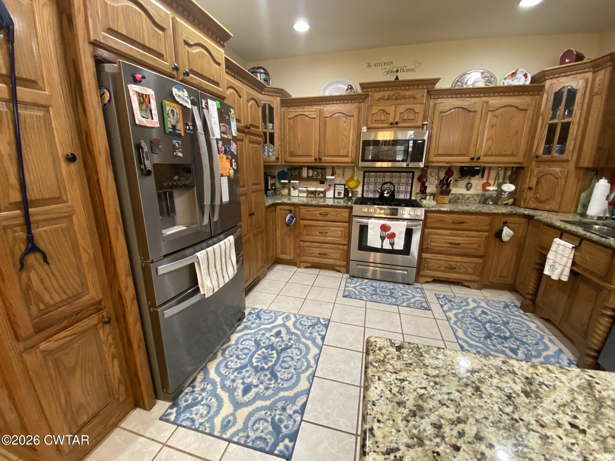 495 Knuckles Road Henderson, TN 38340 - Photo 19 of 80 a kitchen with stainless steel appliances granite countertop a refrigerator and stove