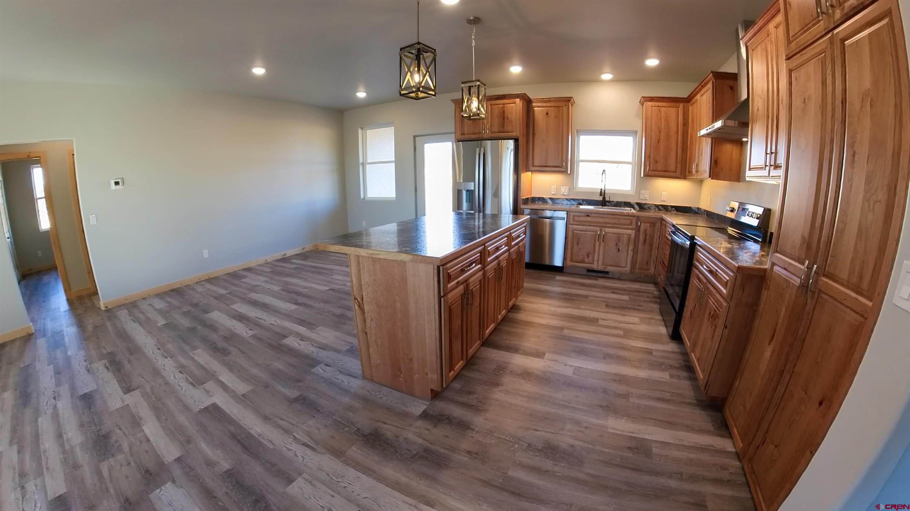 18383 2375 Road Cedaredge, CO 81413 - Photo 3 of 18 a kitchen with stainless steel appliances granite countertop a refrigerator a stove and a wooden floors