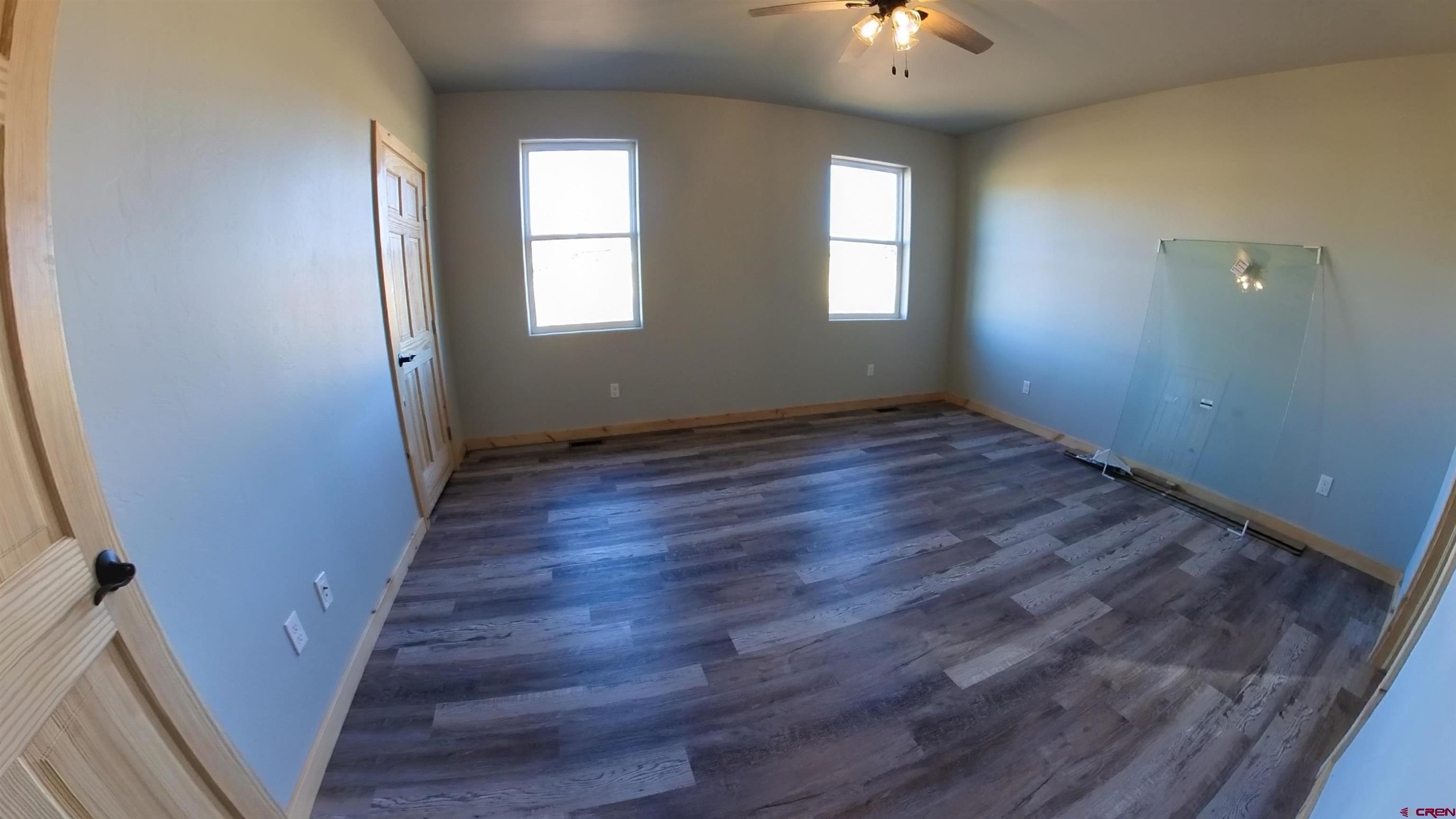 18383 2375 Road Cedaredge, CO 81413 - Photo 6 of 18 a view of an empty room with wooden floor and a window