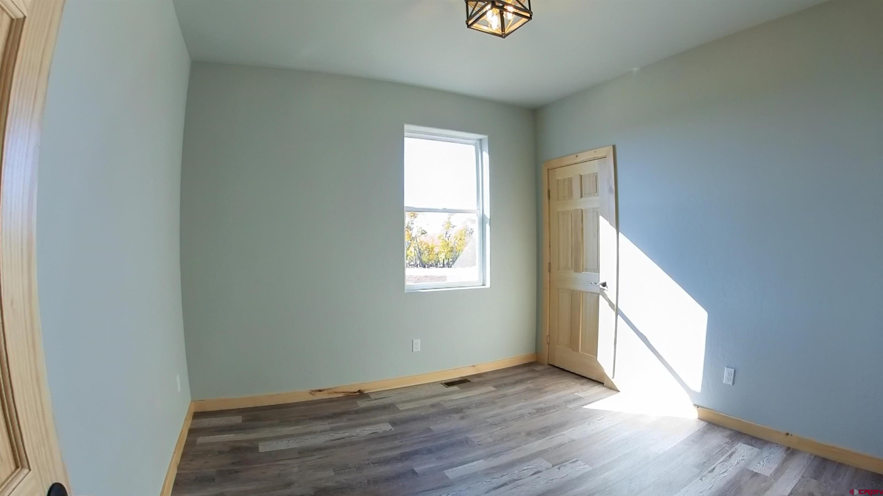 18383 2375 Road Cedaredge, CO 81413 - Photo 7 of 18 a view of an empty room with wooden floor and a window