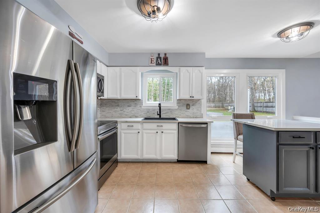10 Ramblewood Road Ridge, NY 11961 - Photo 19 of 39 a kitchen with stainless steel appliances granite countertop a refrigerator and a sink
