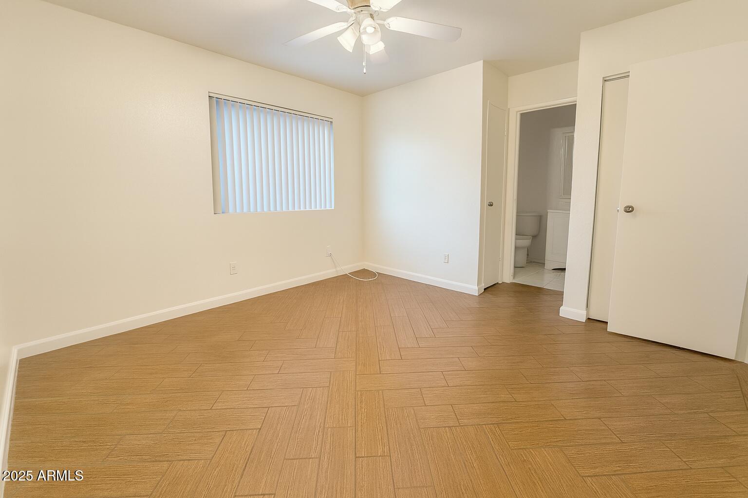 3511 East Baseline Road, Unit 1213 Phoenix, AZ 85042 - Photo 10 of 19 an empty room with a chandelier fan and windows